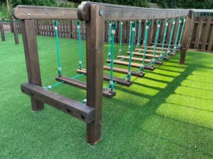 Artificial grass installation under play equipment pieces
