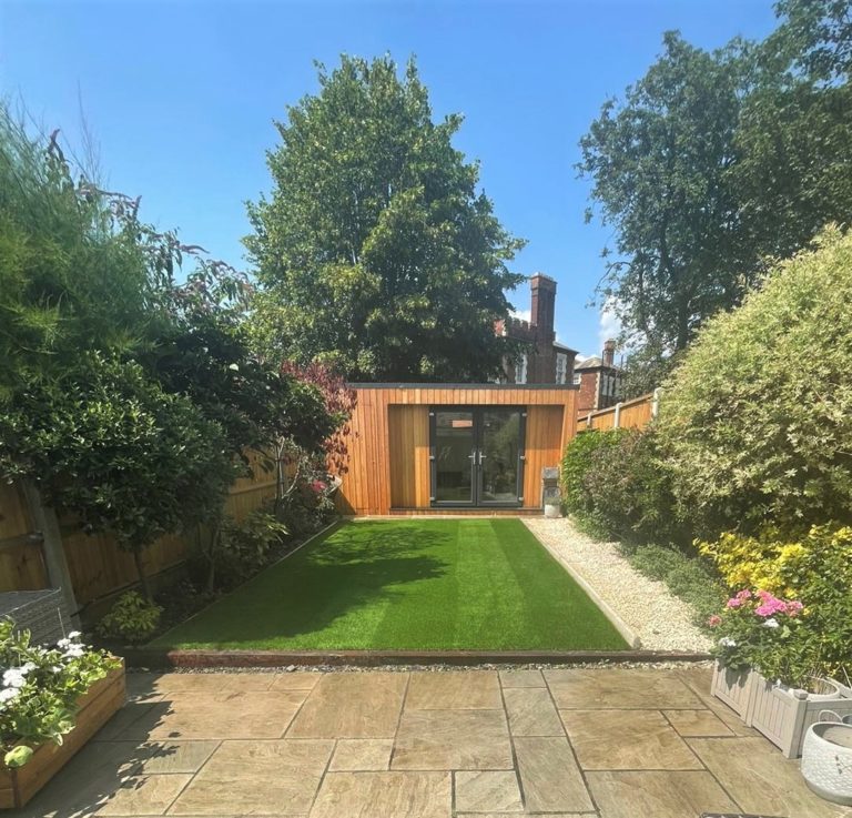 Artificial grass installation leading up to a garden room