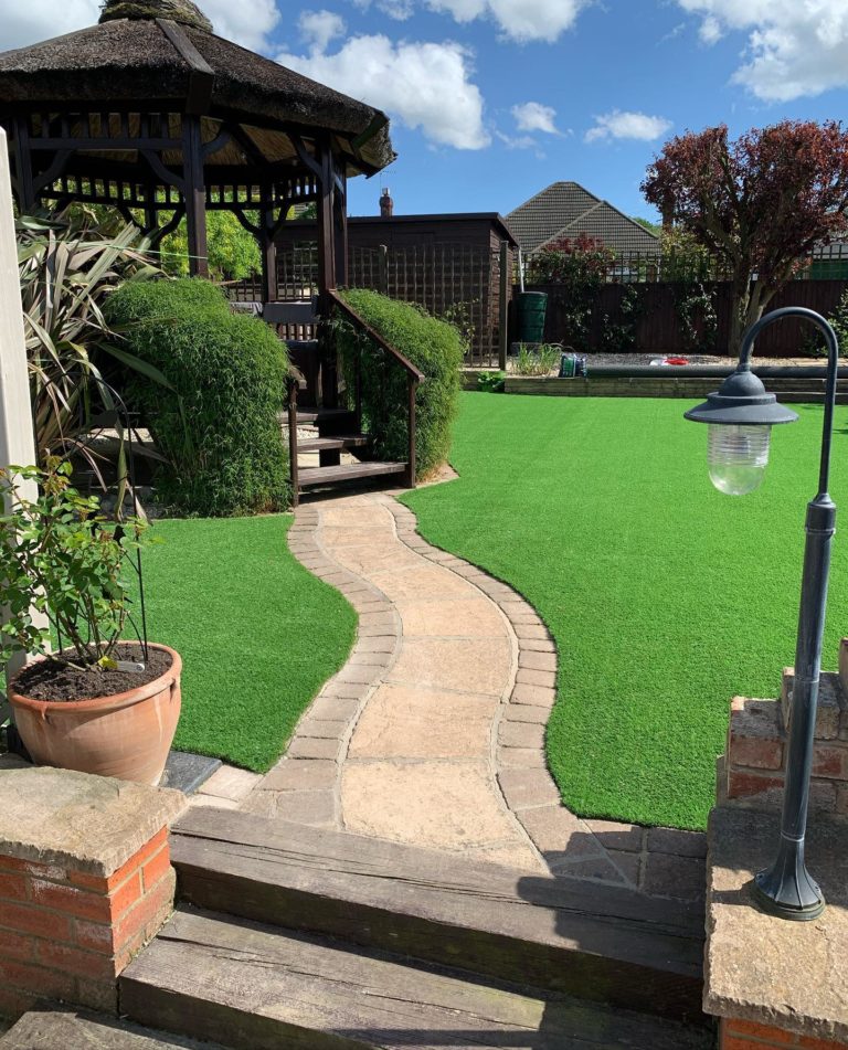 garden with curved path through artificial lawn