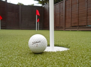 golf ball next to hole
