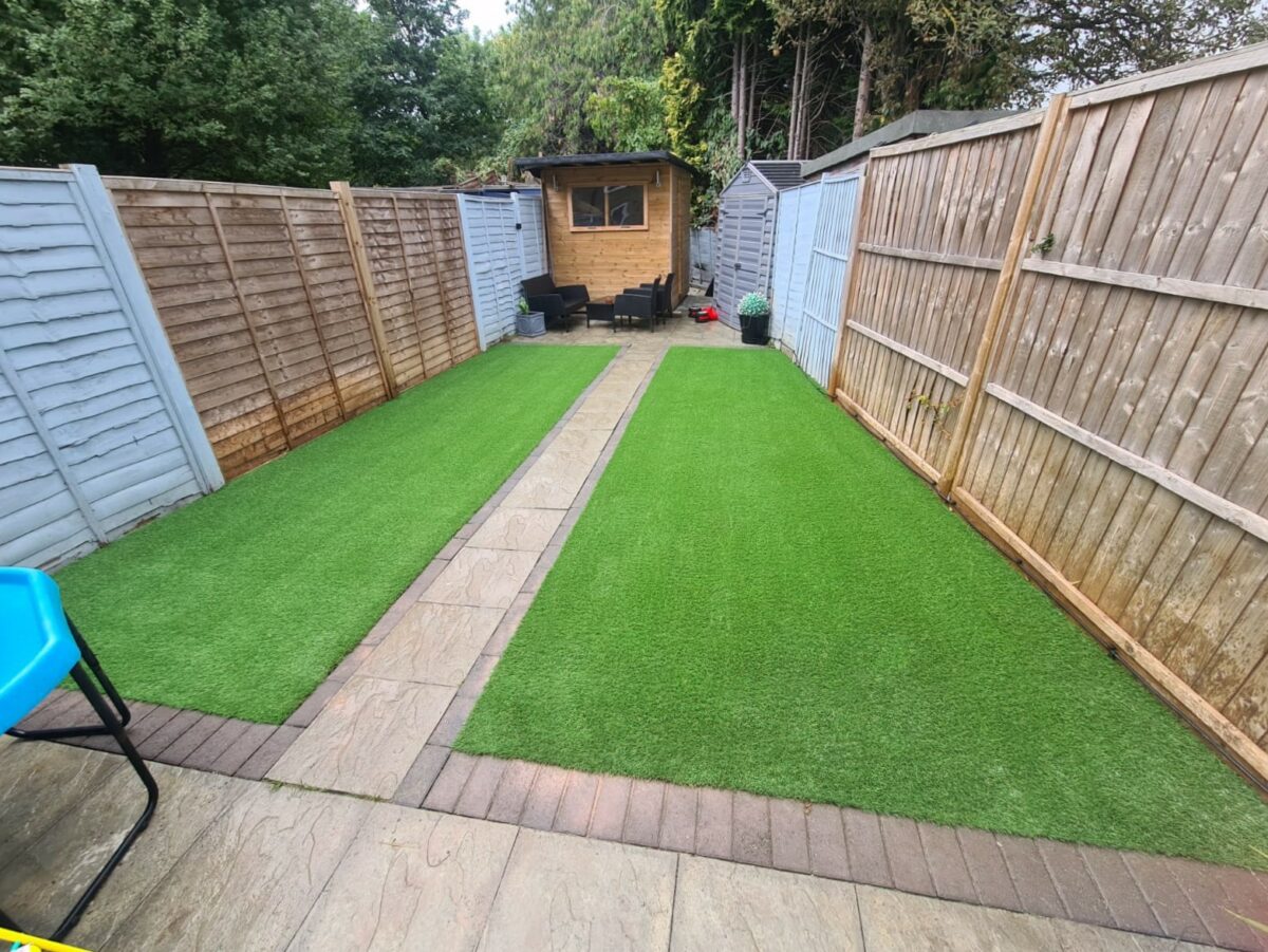 A new artificial lawn with a path through the middle that is soft, green and even.